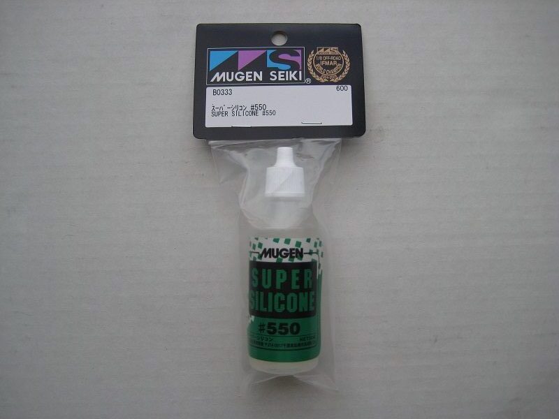 A bottle of green paint sitting in its packaging.