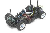 A remote controlled car with many wires on the floor.