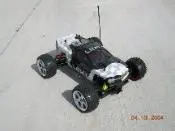 A remote controlled car is parked on the concrete.